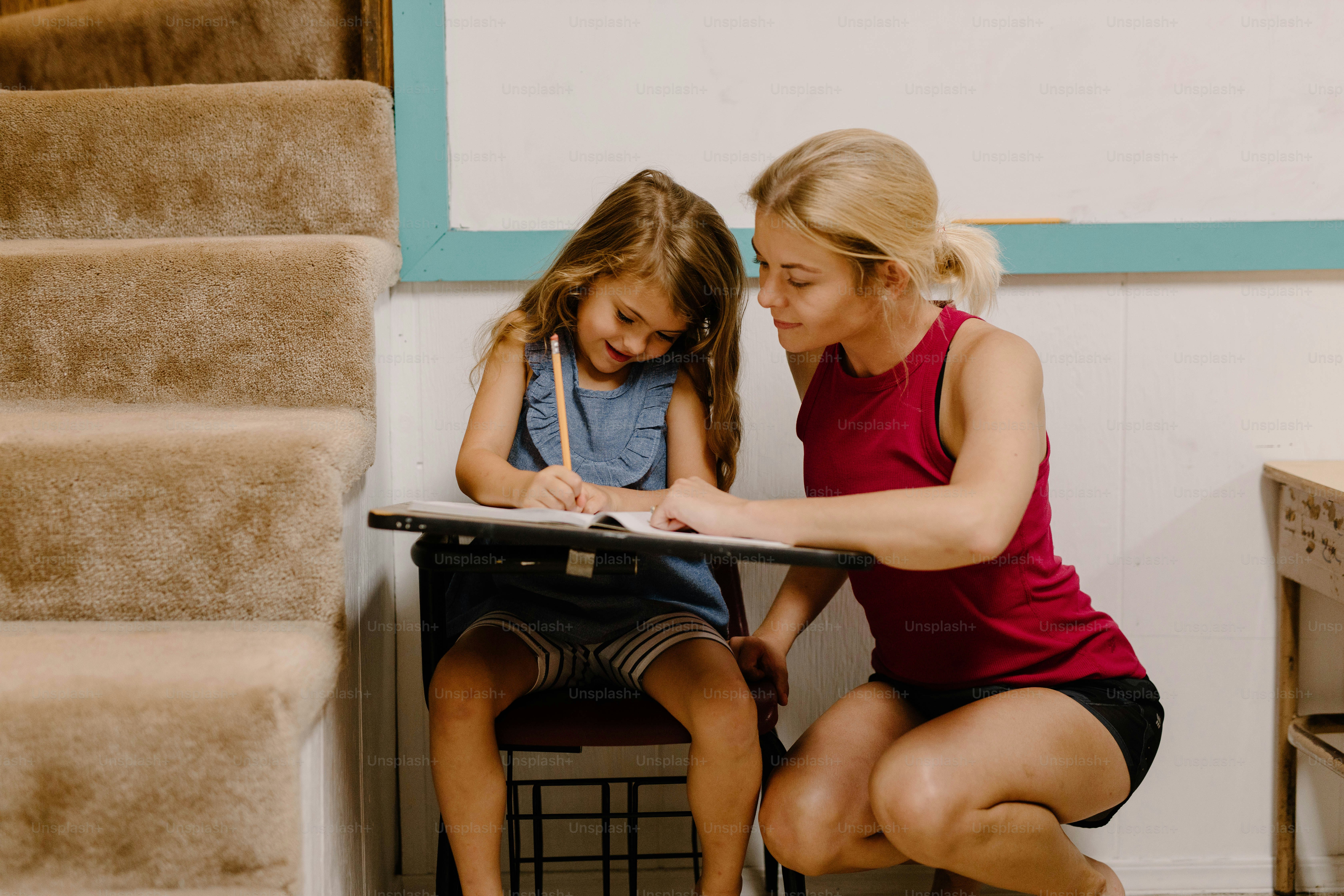 a woman sitting next to a little girl at a table