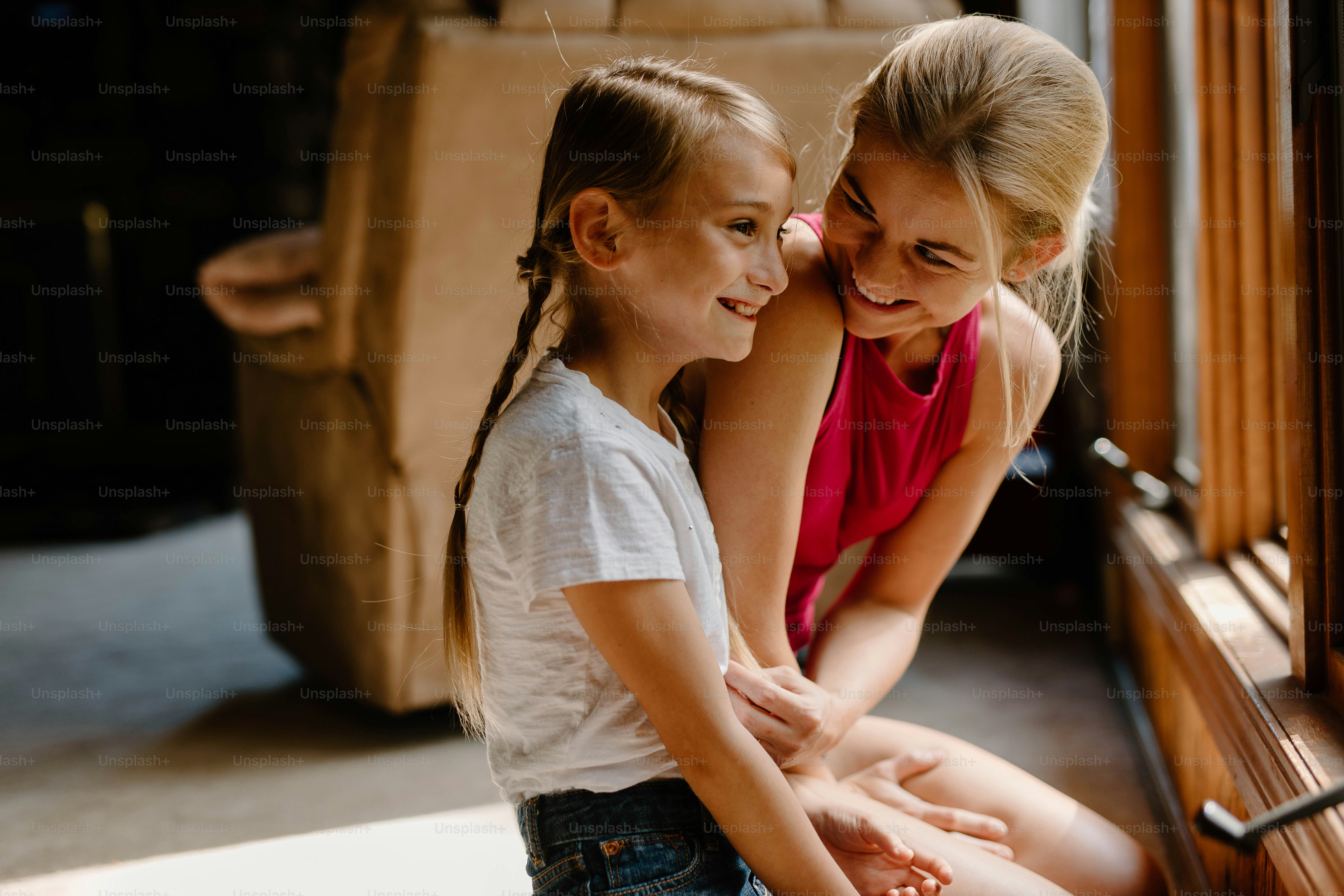 two young girls are sitting on a bench