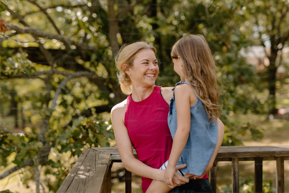 a mother and daughter sitting on a park bench