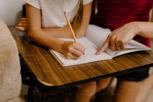 two people sitting at a table with a notebook and pen