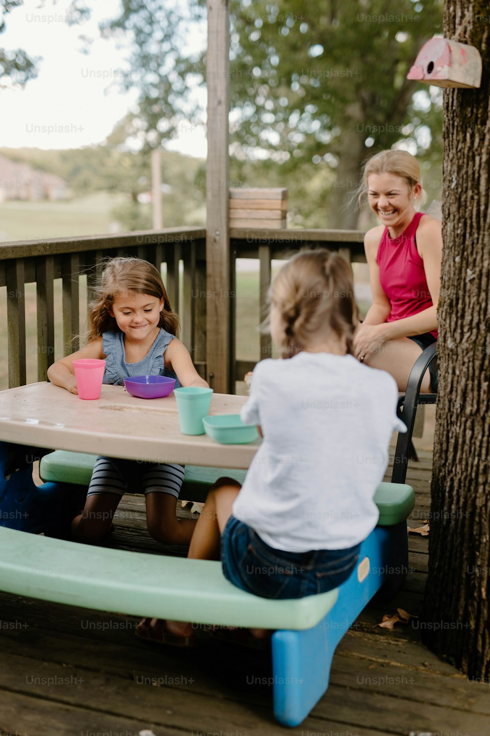 a group of children sitting at a picnic table