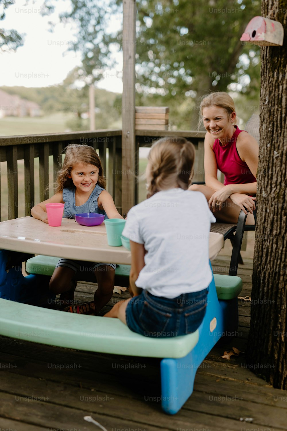 a group of children sitting at a picnic table