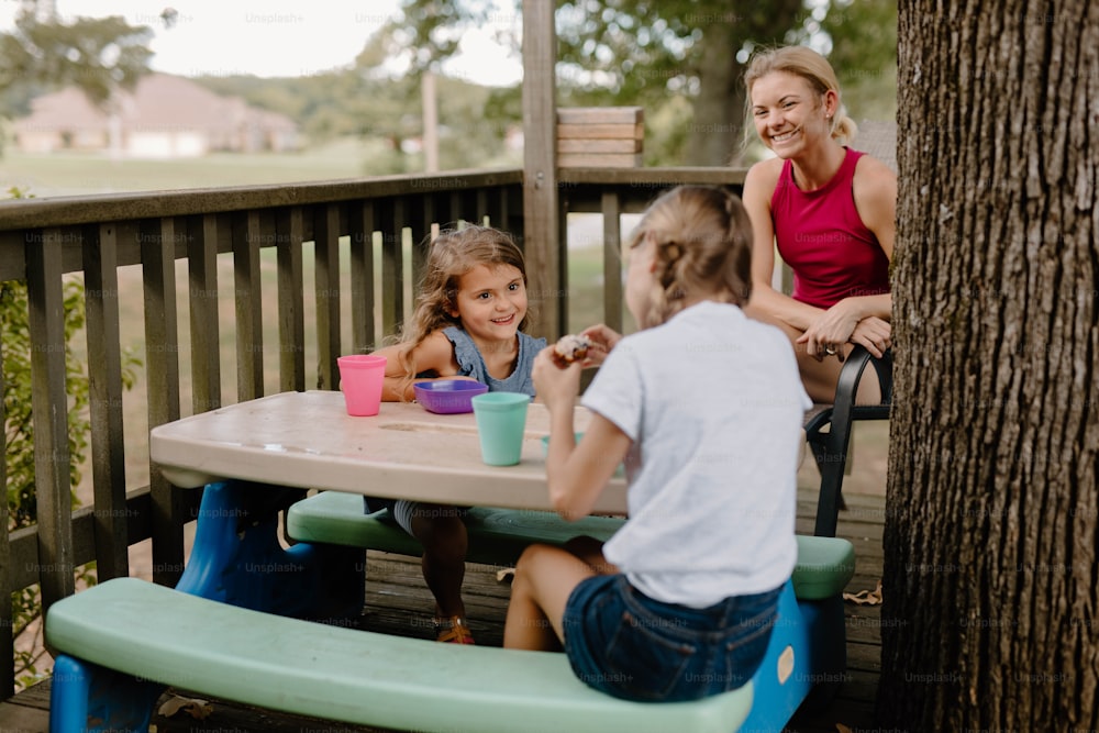 um grupo de crianças sentadas em uma mesa de piquenique