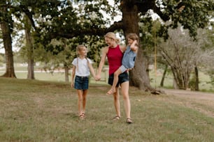 a group of young girls walking across a lush green field