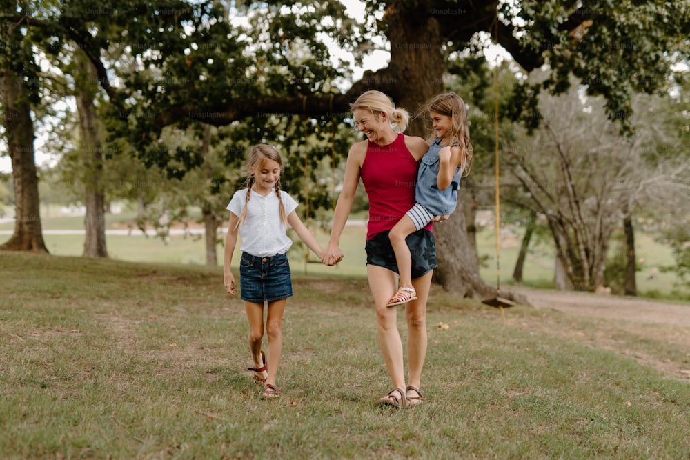a group of young girls walking across a lush green field