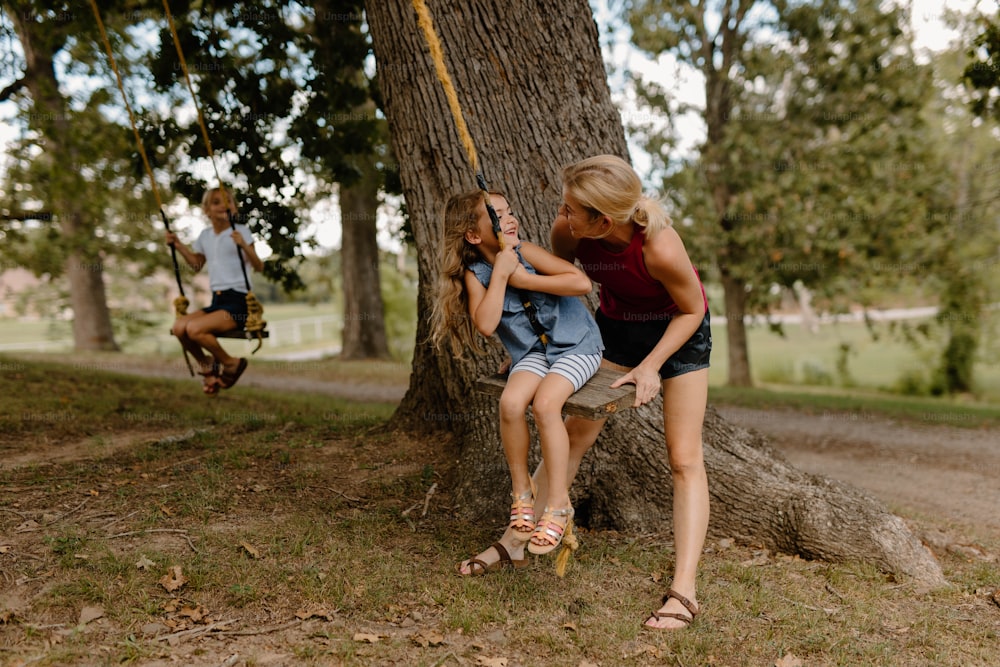 duas meninas sentadas em um balanço em um parque