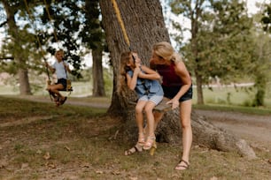 Zwei Mädchen sitzen auf einer Schaukel in einem Park