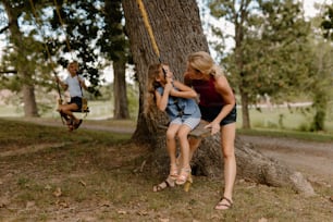 two girls sitting on a swing in a park