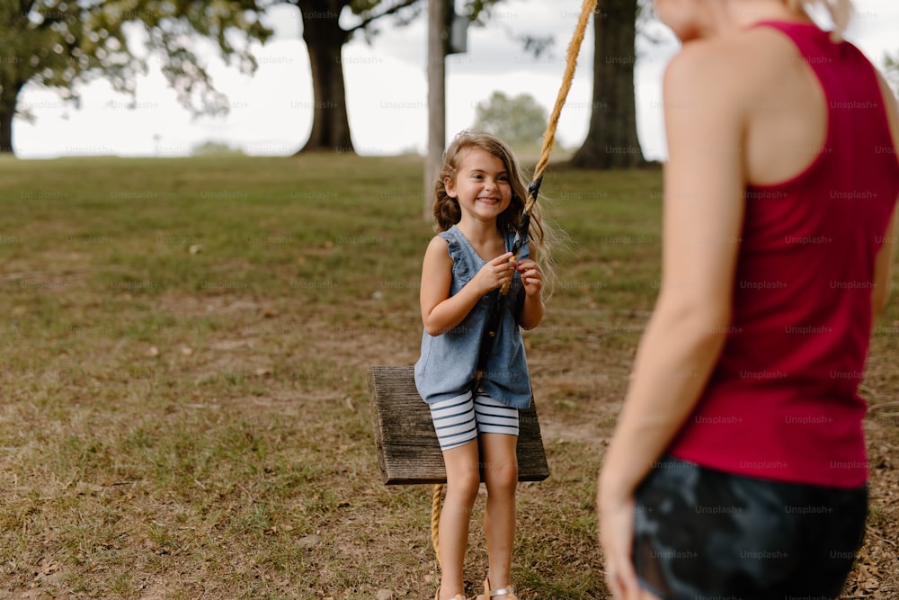 Une petite fille tenant une batte de baseball dans un champ