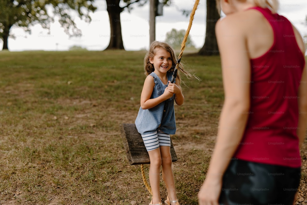 uma menina segurando um taco de beisebol em um campo