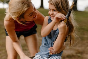 a woman holding a baseball bat next to a little girl