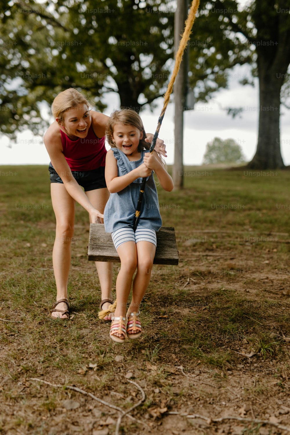 a young girl holding a baseball bat next to a young girl