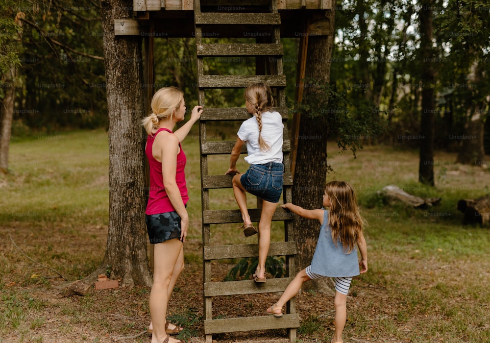 a group of young girls climbing up a wooden ladder