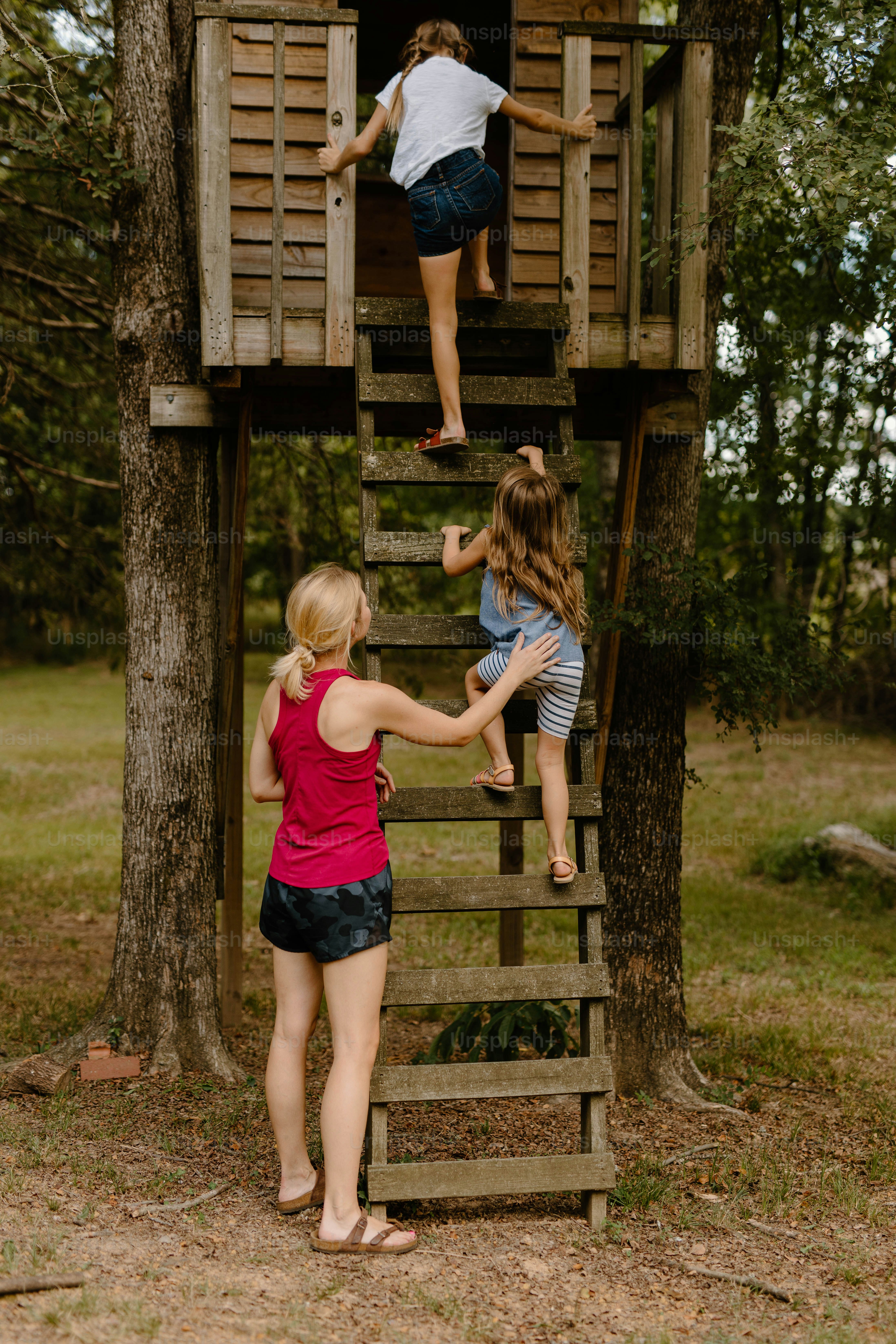 a group of children climbing up a tree house