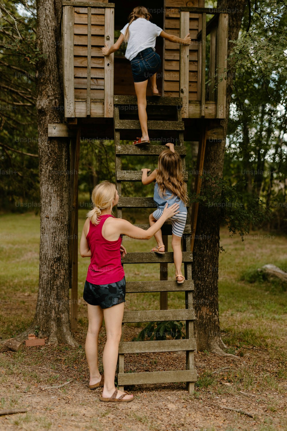 Eine Gruppe von Kindern, die auf ein Baumhaus klettern