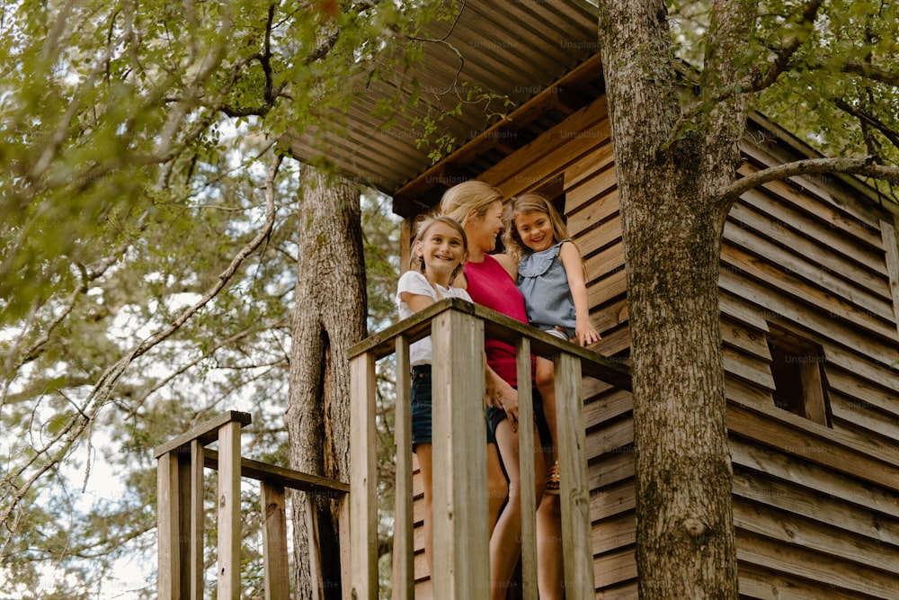 three young girls standing on a wooden deck