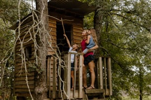 Eine Frau und ein Kind, die auf einem Baumhaus stehen