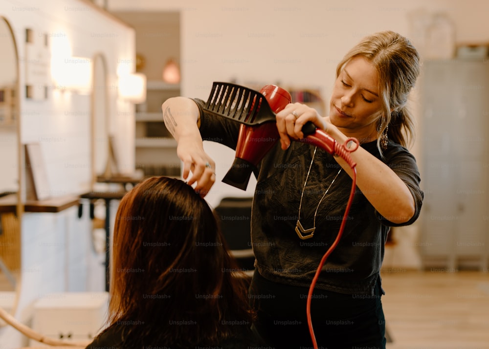 a woman blow drying another woman's hair