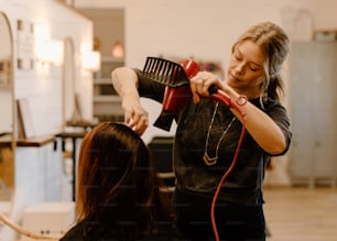 a woman blow drying another woman's hair