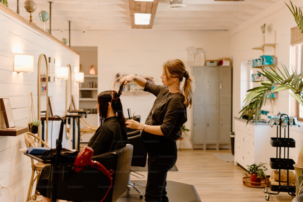 uma mulher cortando o cabelo de outra mulher em um salão de beleza