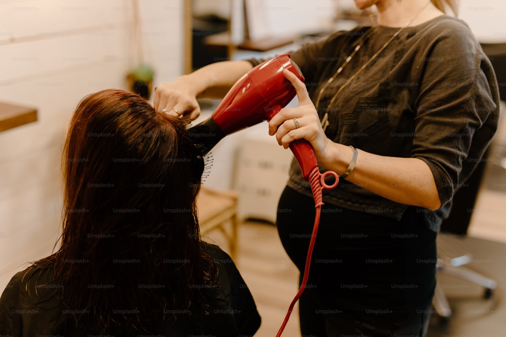 Una mujer secando el cabello de otra mujer