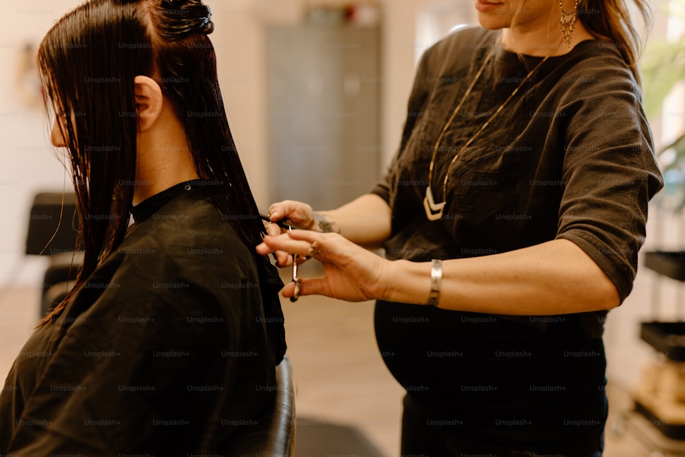 a woman cutting another woman's hair in a salon