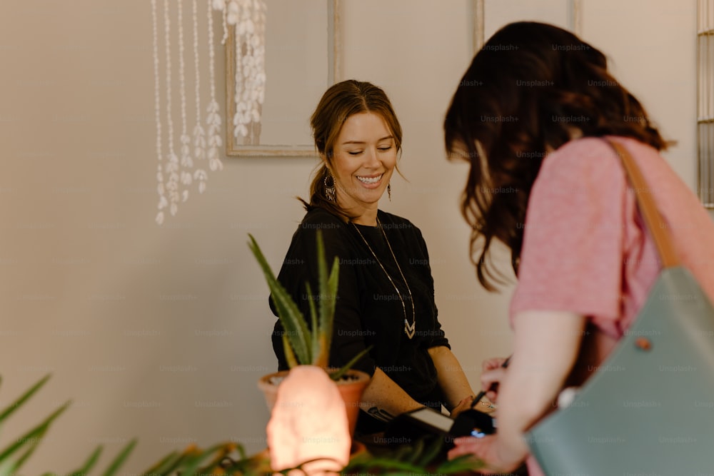 a woman standing next to another woman in a room