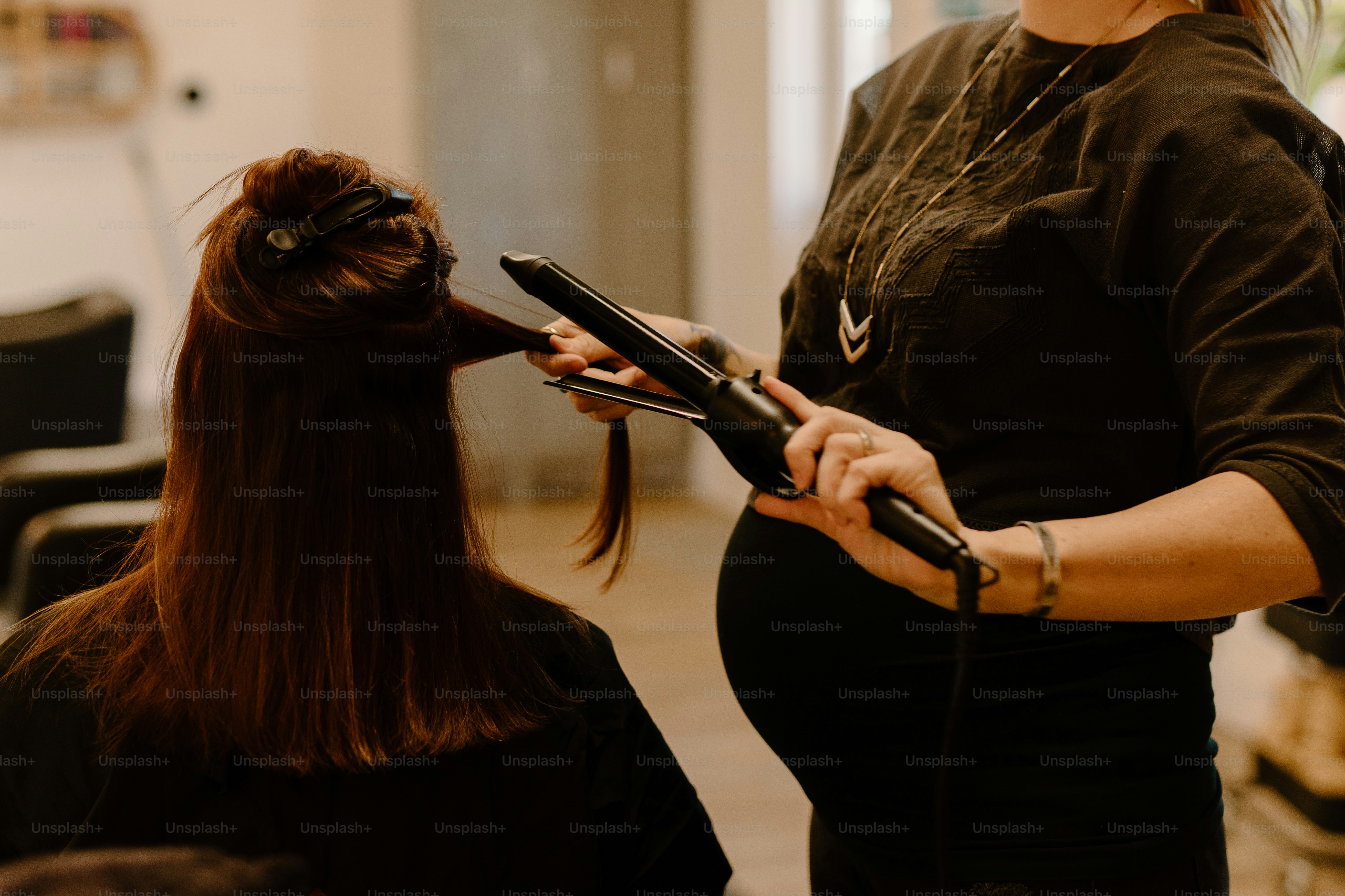 a woman is blow drying her hair in a salon