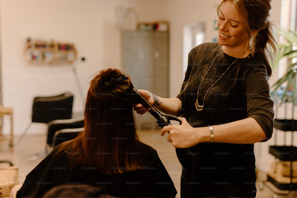 Eine Frau, die einer anderen Frau in einem Salon die Haare schneidet