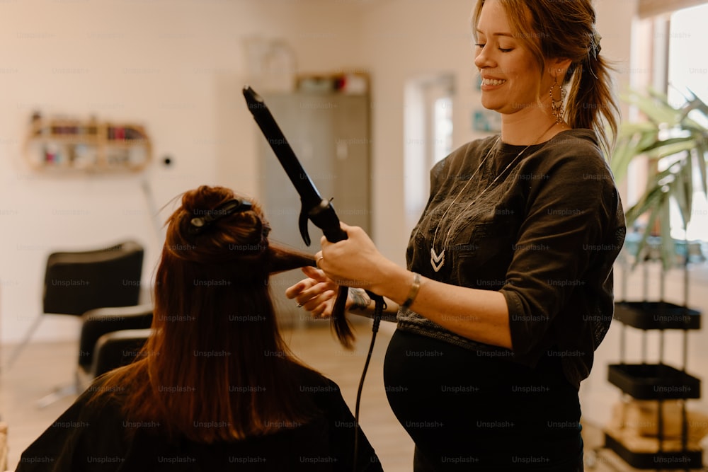 a woman cutting another woman's hair in a salon