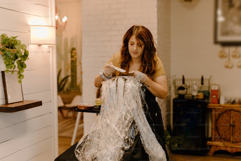 uma mulher sentada em uma cadeira segurando um saco plástico