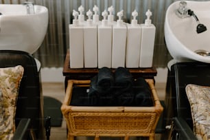 a basket of black towels sitting in front of a sink