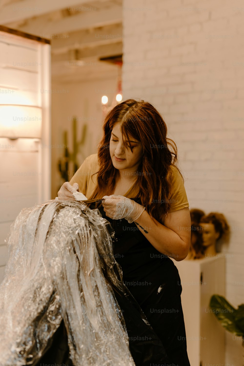 a woman in a yellow shirt is cutting a piece of fabric