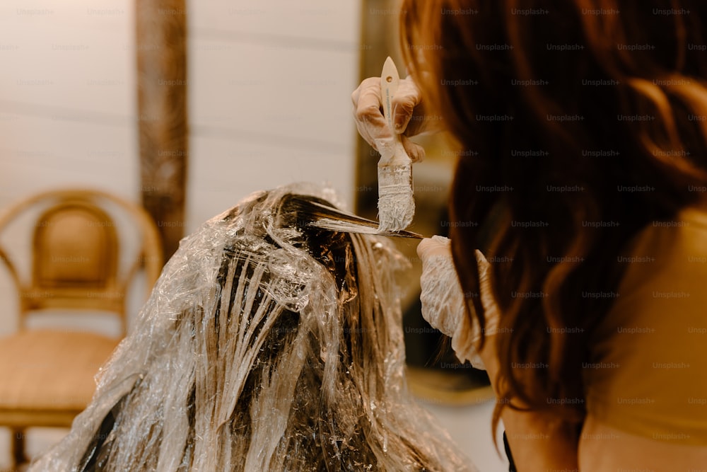 uma mulher está fazendo o cabelo em um salão