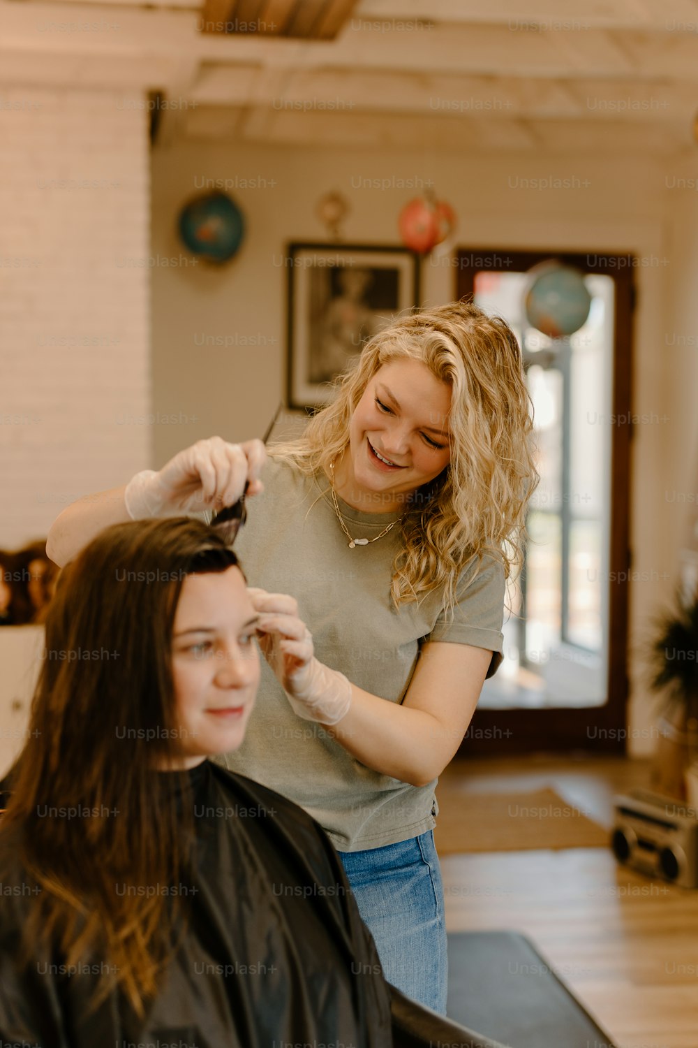 a woman cutting another woman's hair in a salon