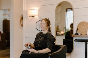 una donna seduta su una sedia in un parrucchiere