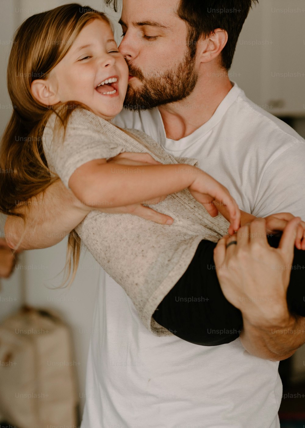 Un hombre sosteniendo a una niña en sus brazos