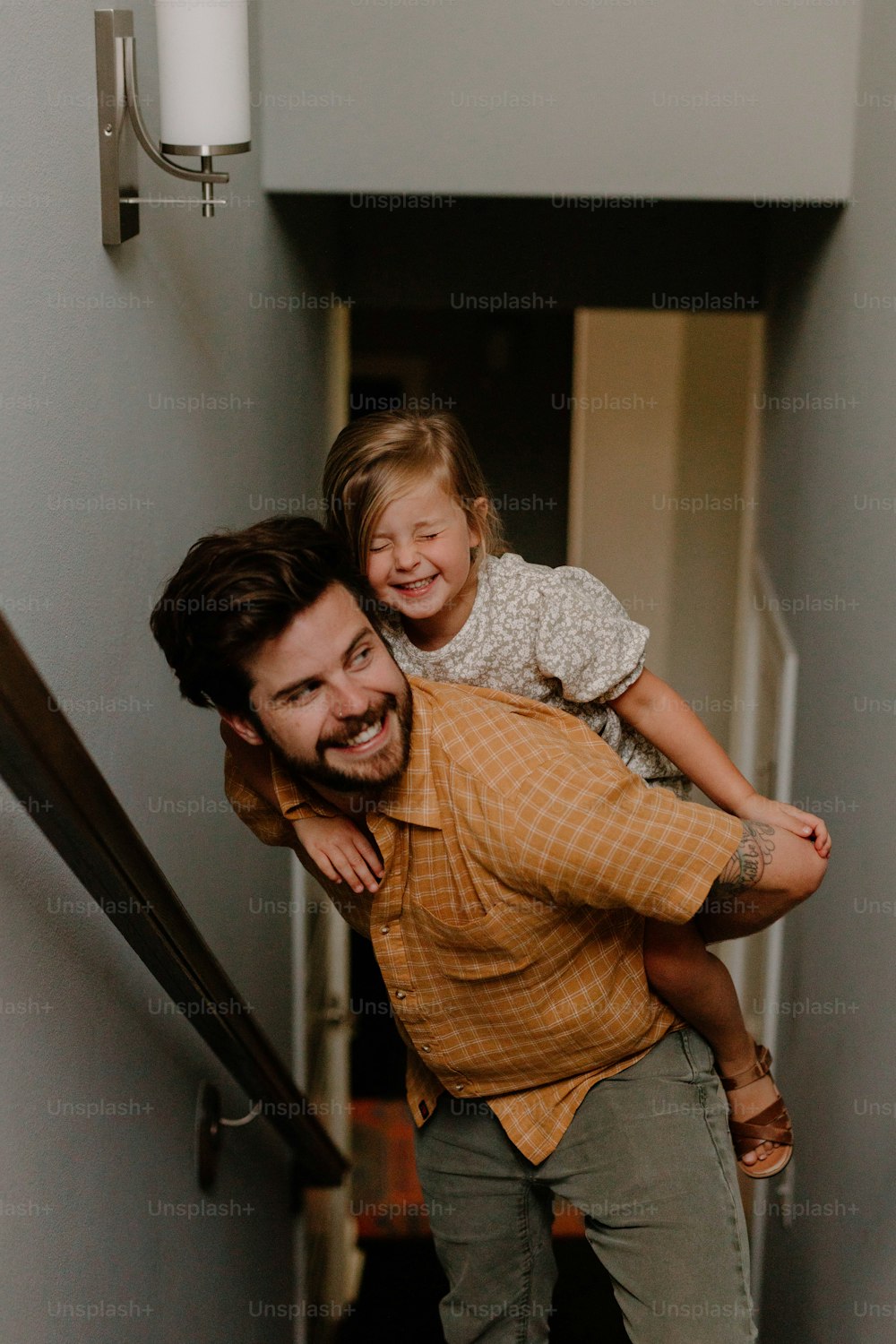 a man carrying a little girl up a flight of stairs