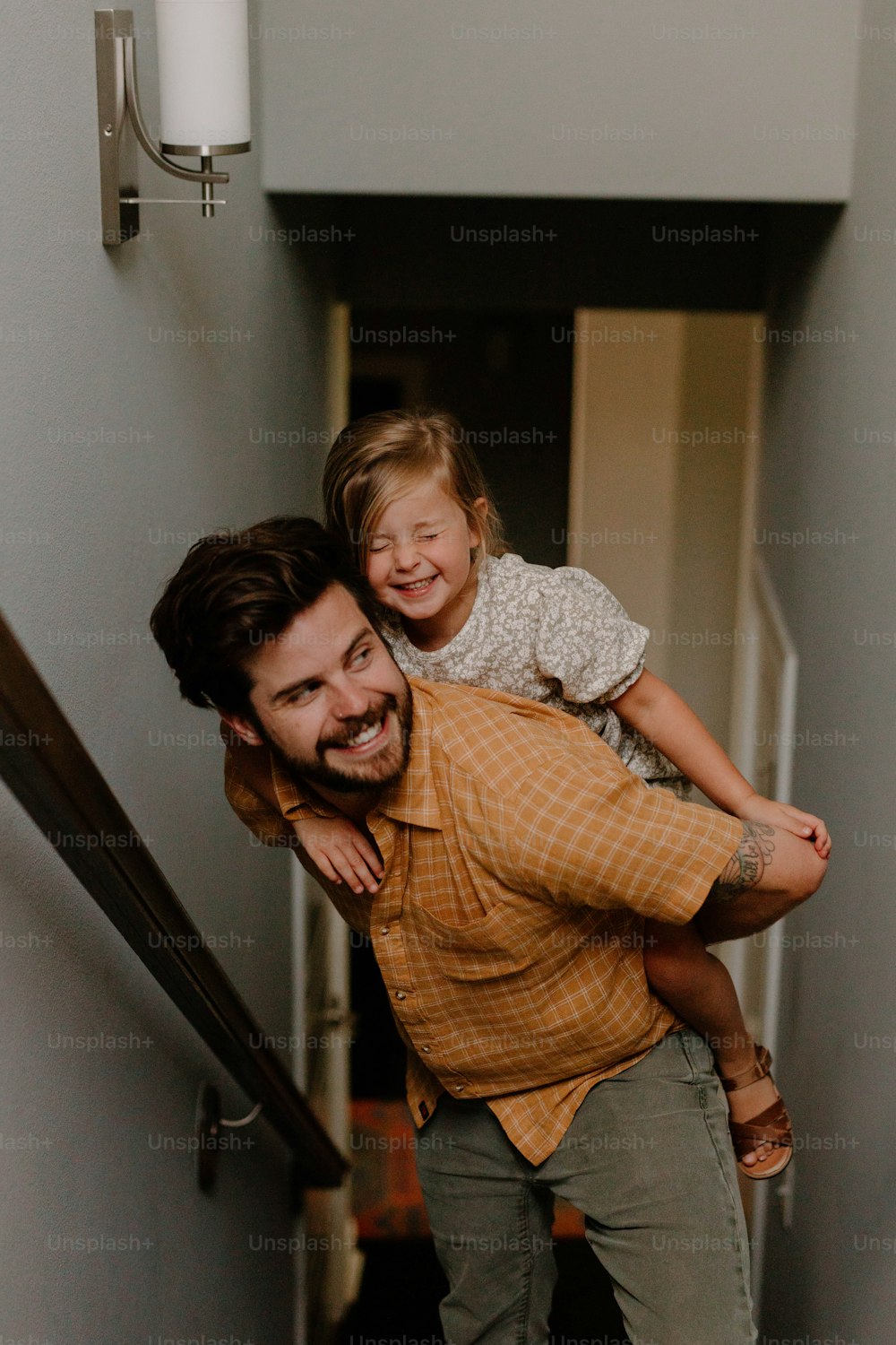 a man carrying a little girl up a flight of stairs
