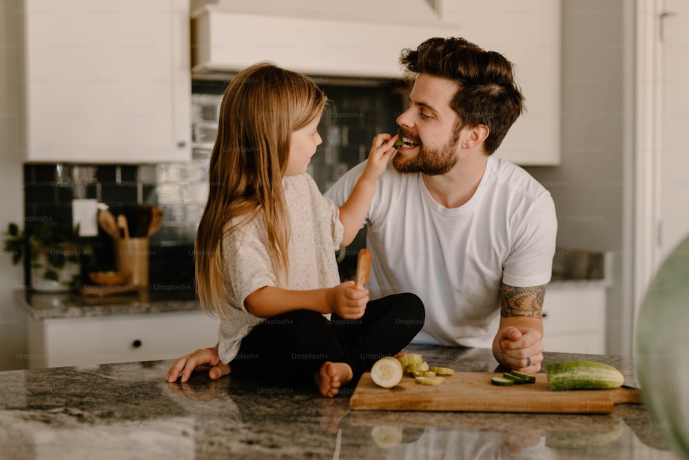 Ein Mann und ein kleines Mädchen sitzen auf einer Küchentheke