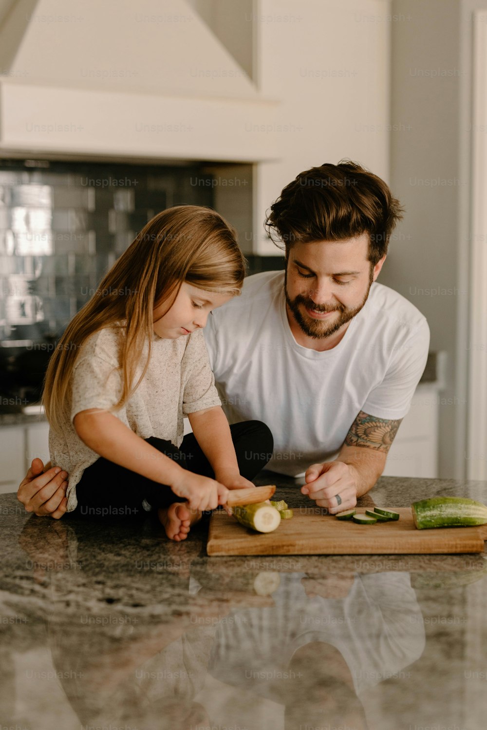a man and a little girl cutting vegetables on a cutting board
