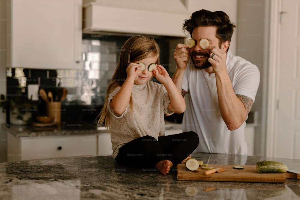 a man and a little girl sitting on a kitchen counter