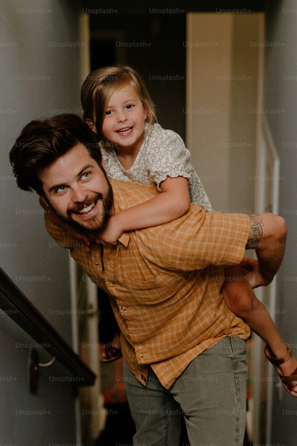 a man carrying a little girl up a flight of stairs