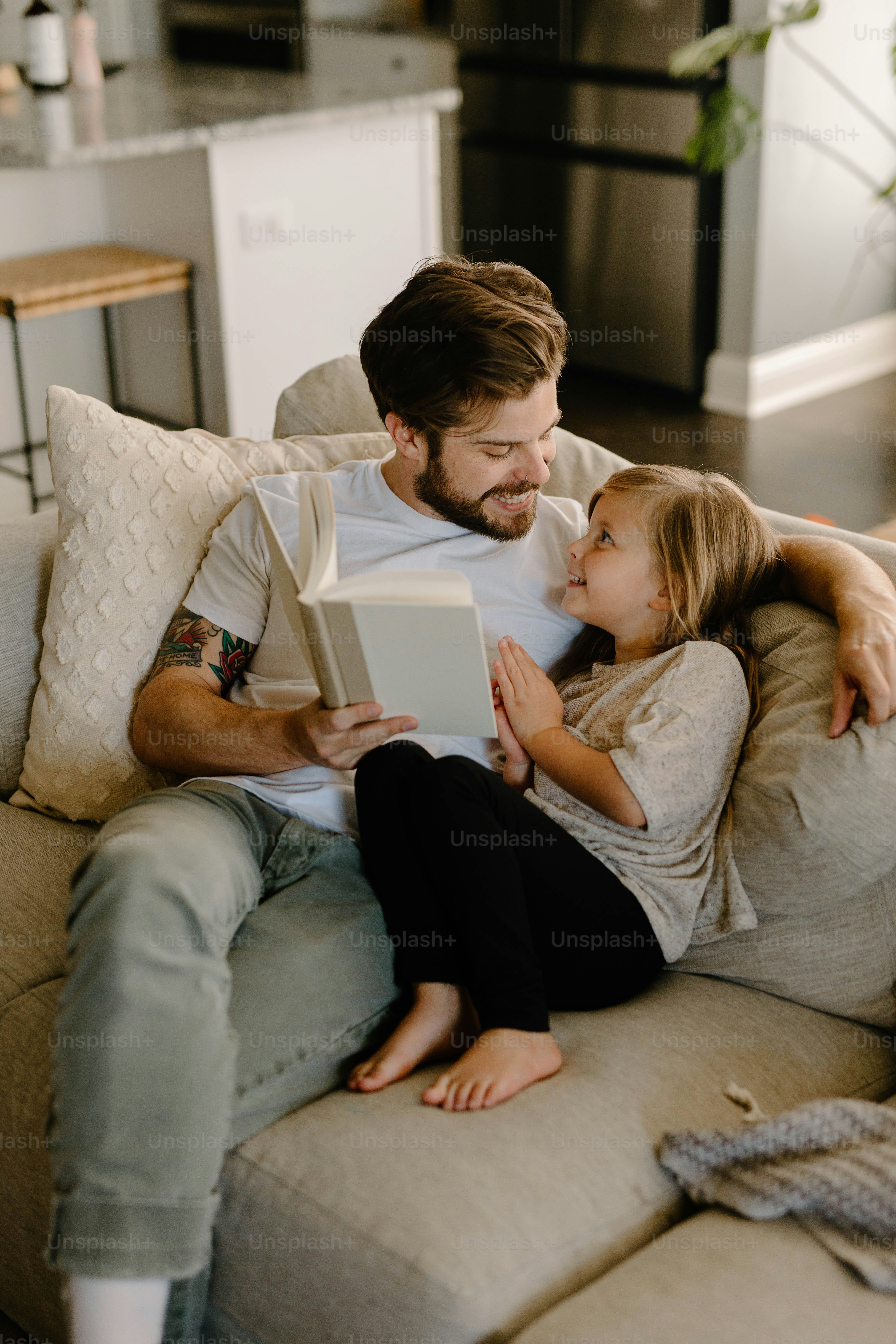 Father reading with his daughter on the sofa