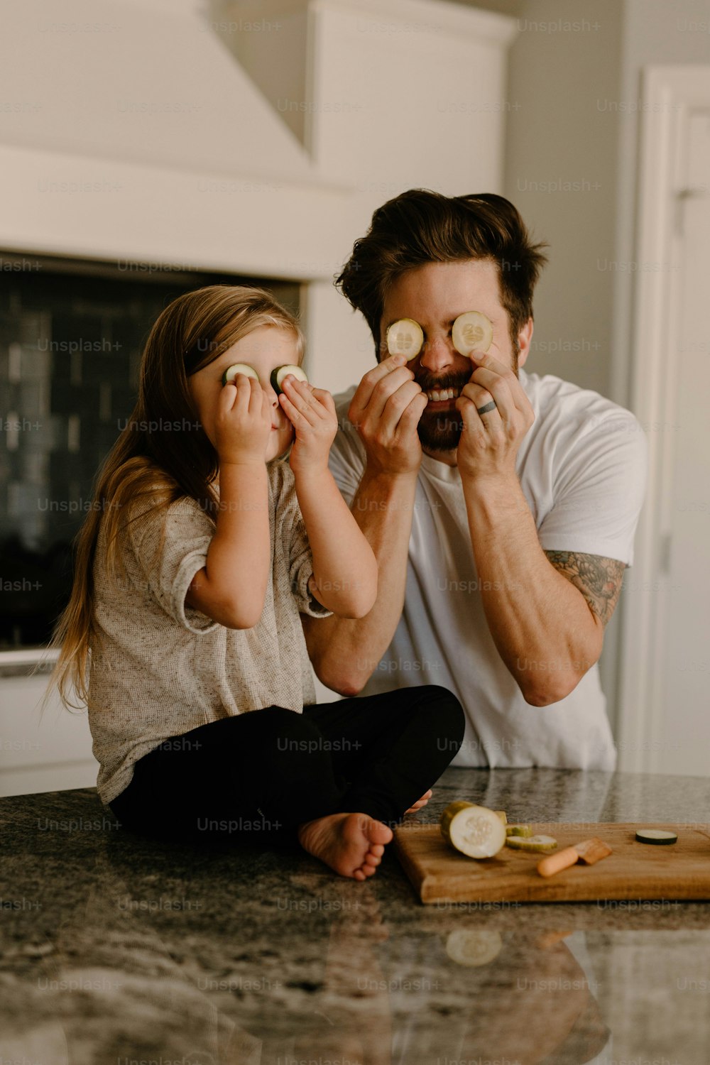 a man and a little girl sitting on a kitchen counter