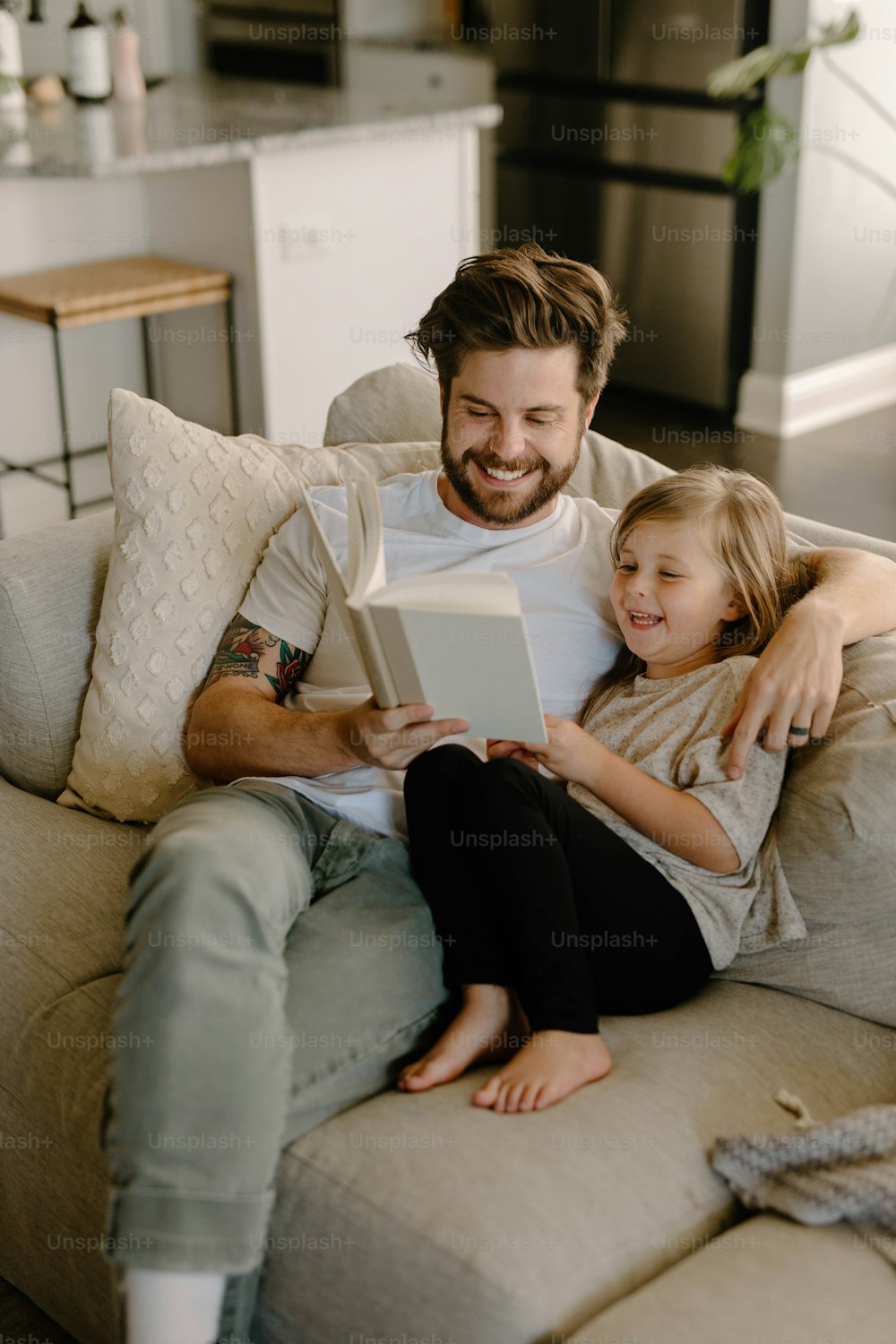 a man and a little girl sitting on a couch