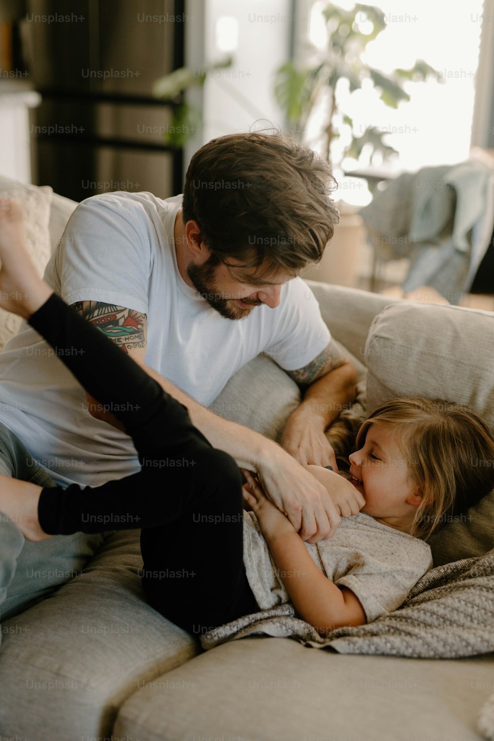 a man and a little girl laying on a couch