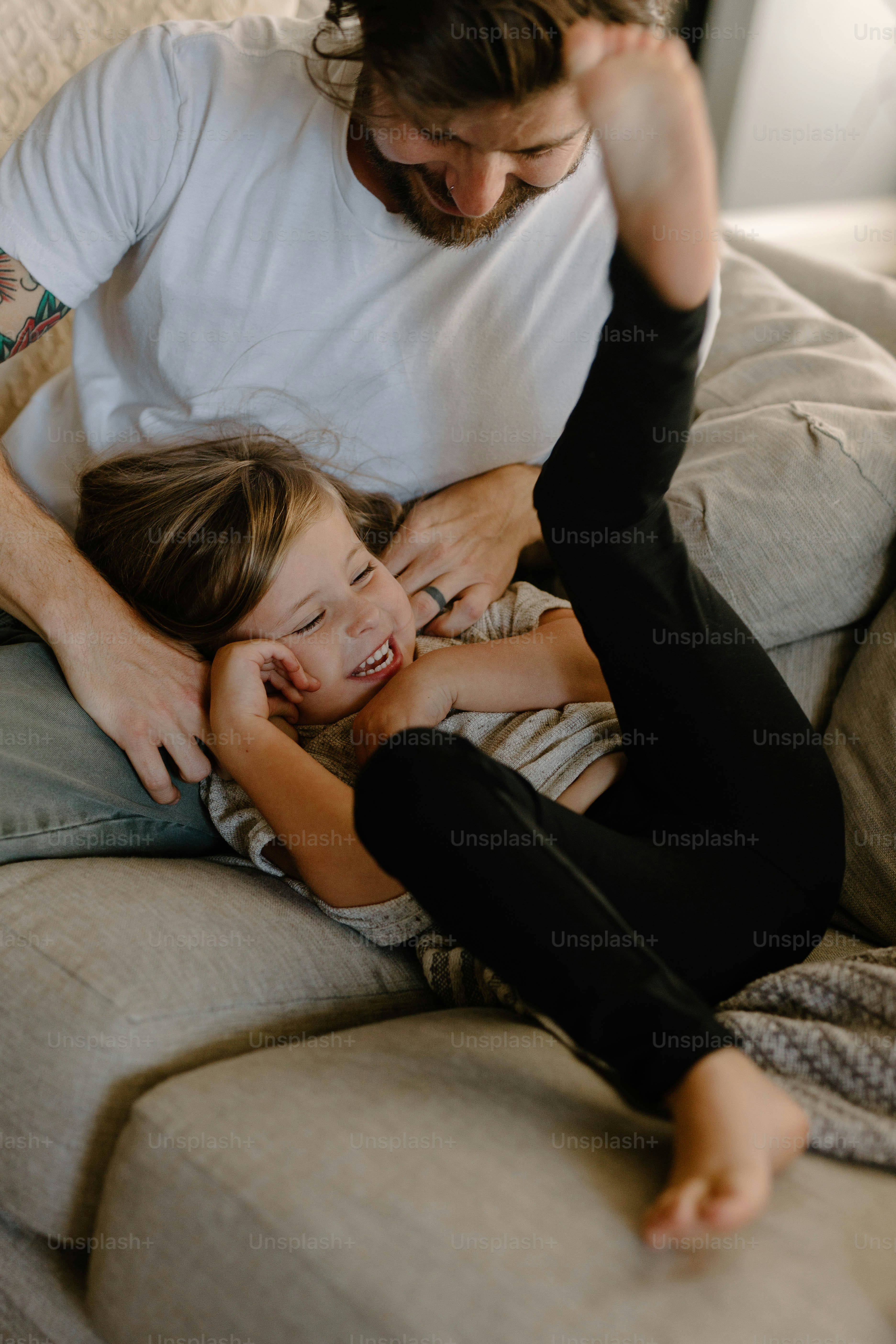a man and a little girl sitting on a couch