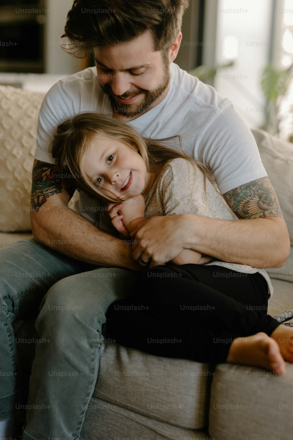 a man and a little girl sitting on a couch