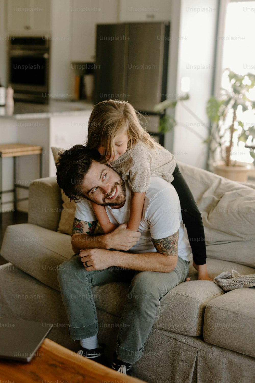 a man sitting on a couch holding a little girl